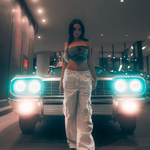 Daniella Rose Rucker is in front of a vintage car.